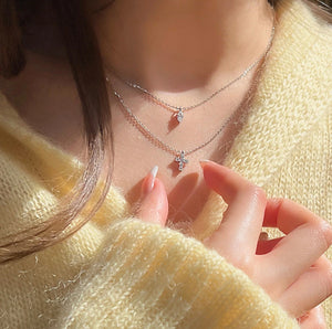 Layered Mini Cross Rhinestone Necklace styled with different outfits, demonstrating its versatility and elegant appeal, yellow sweater.