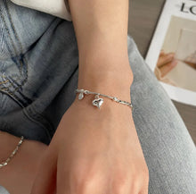 Load image into Gallery viewer, Heart Charm Bead Bracelet displayed on a wrist, showcasing its adjustable fit and refined style.