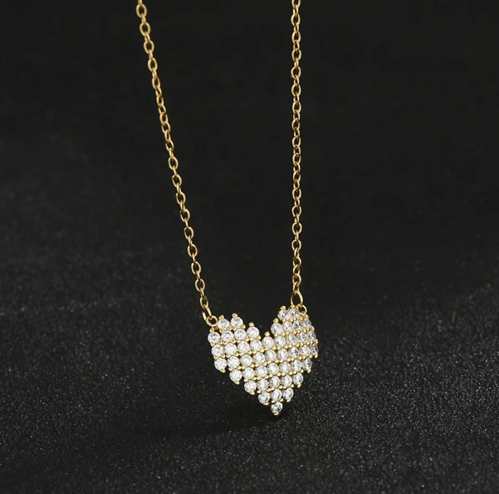 Rhinestone Heart Necklace on a gold chain against a black background