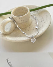 Load image into Gallery viewer, Close-up of the heart charm and bead detail on the sterling silver bracelet, highlighting its elegant design.