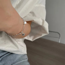 Load image into Gallery viewer, Heart Charm Bead Bracelet displayed on a wrist, showcasing its adjustable fit and refined style, jeans and white shirt.