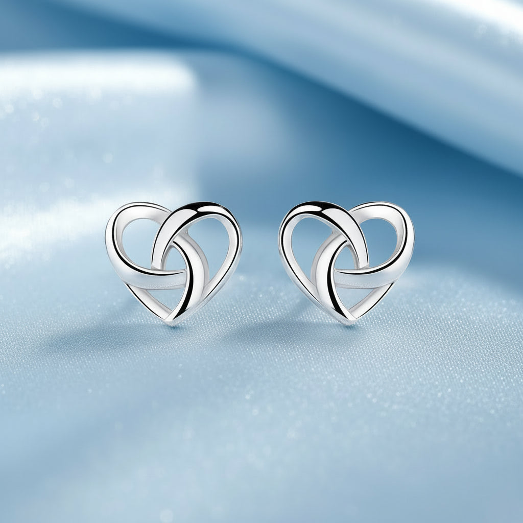 Pair of silver Infinity Knot Heart Earrings on a soft background