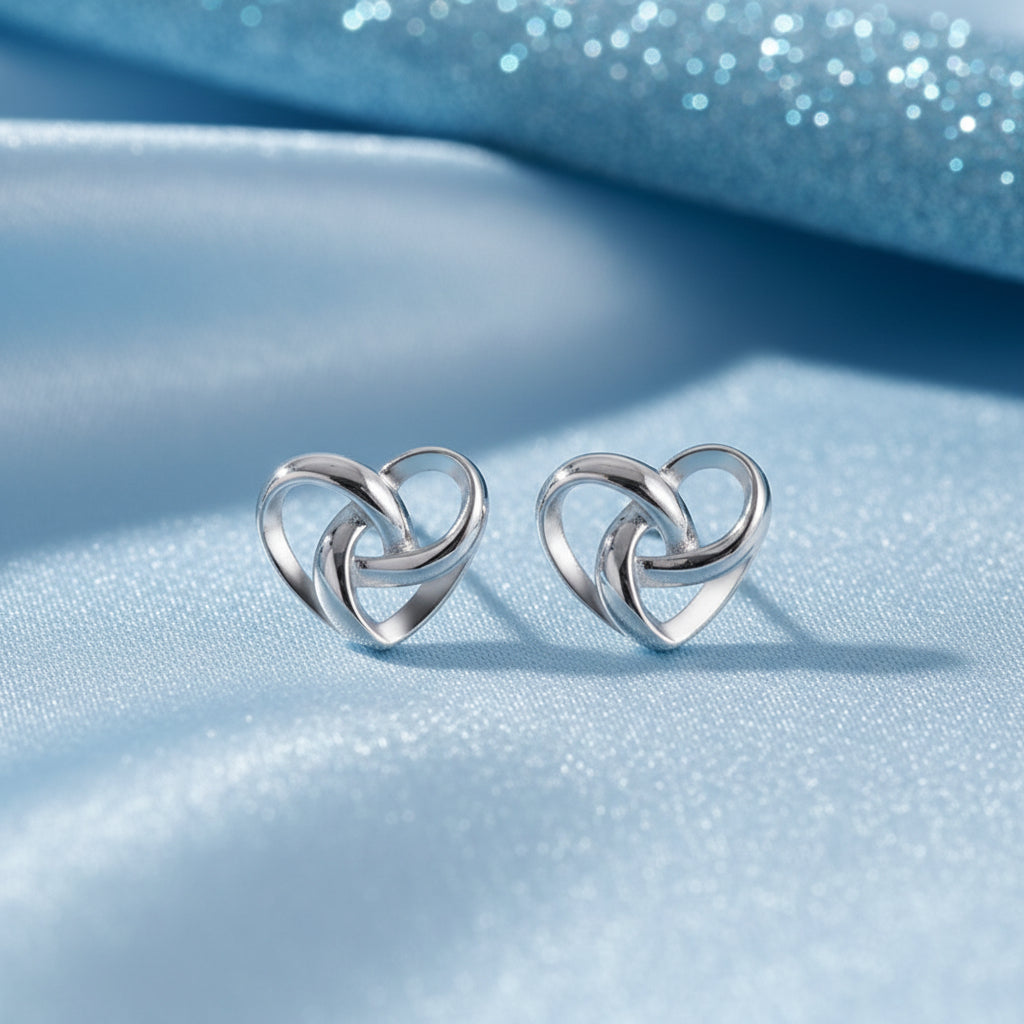 Infinity Knot Heart Earrings on a blue fabric background