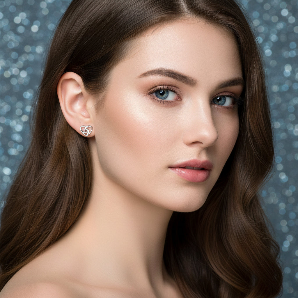 Infinity Knot Heart Earrings worn on an ear with a dark background