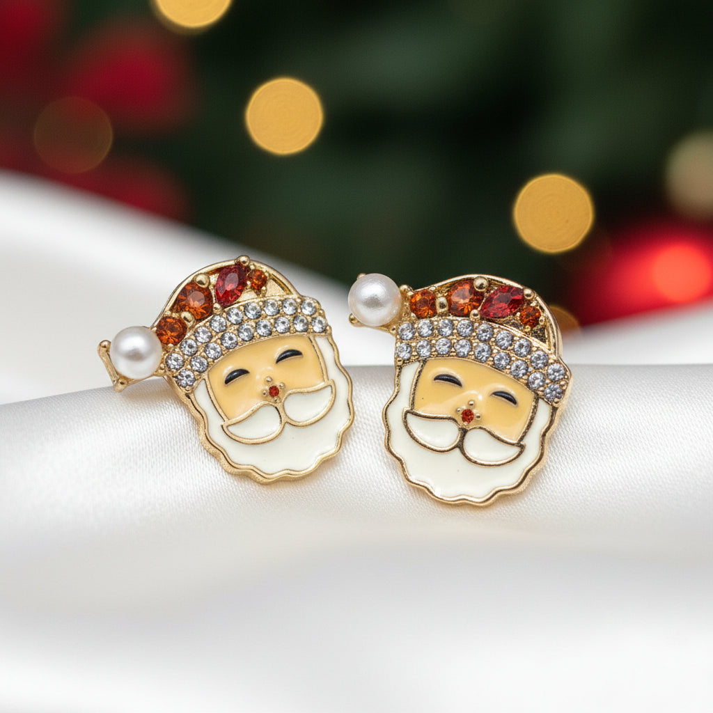 A pair of Jeweled Santa Claus Earrings displayed on a round white backing card, held by a person's fingers. The earrings feature gold-plated edges, white faux pearls, clear rhinestones, and yellow and orange enamel details.