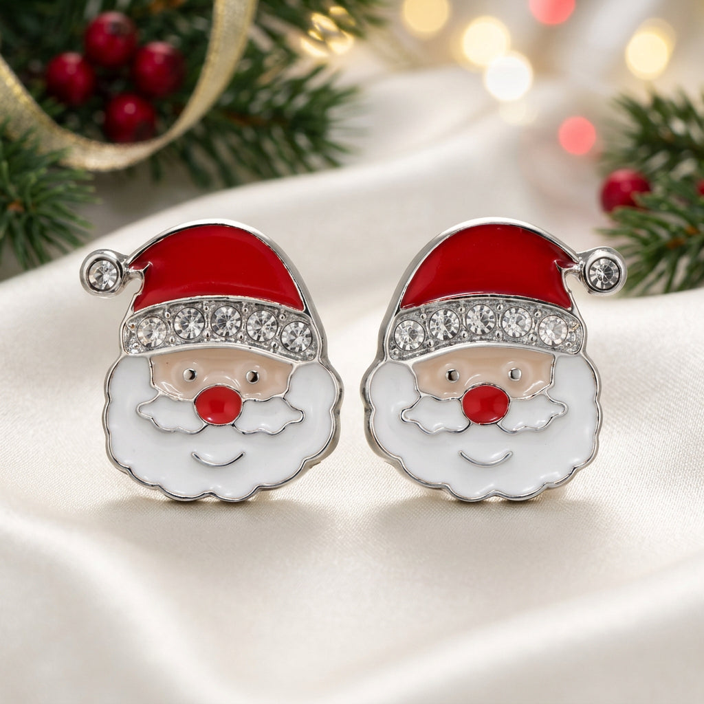 A pair of Jolly Santa Earrings with red enamel hats, white enamel beard, and clear rhinestone trim, set in silver-tone metal on a warm beige background.