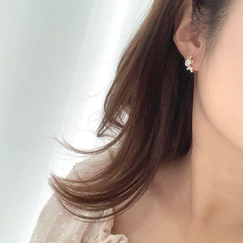 Close-up of a Gold Zircon Reindeer Earrings worn by a person with a neutral background