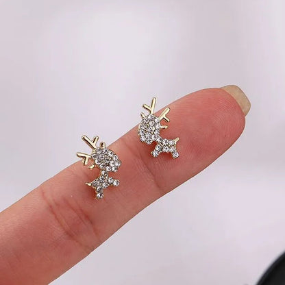 Gold Zircon Reindeer Earrings held between fingers against a light background