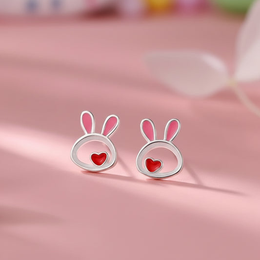 Silver Little Love Bunny Earrings with pink inner ears and red hearts on a pink background