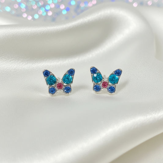 Mini Blue Crystal Butterfly Earrings with colorful gemstones on a round white card.