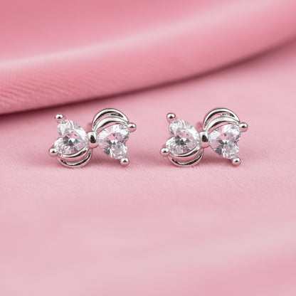 Mini Silver Heart Crystal Bow Earrings on a pink background