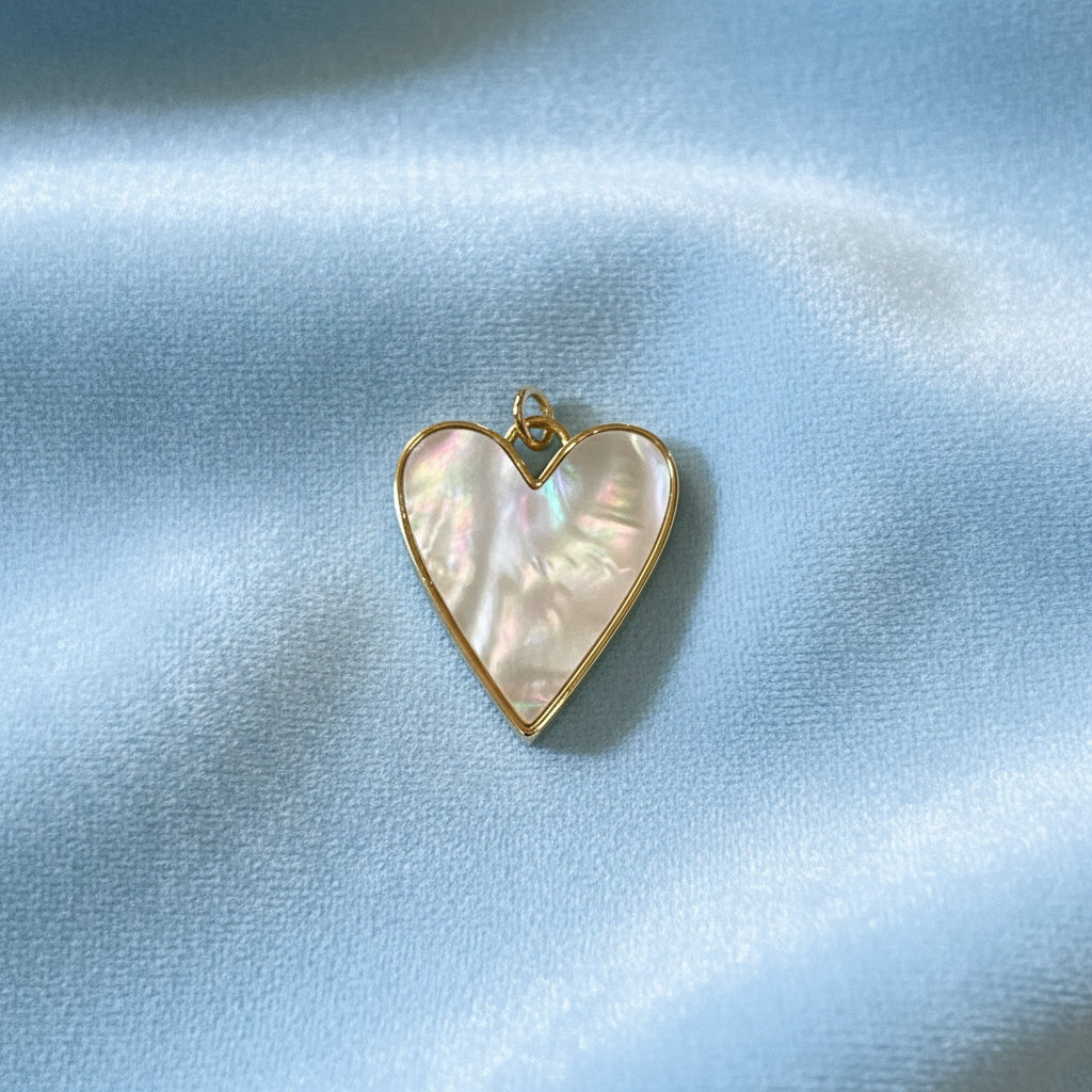 Mother-of-Pearl Heart Charm with gold border on blue (front view)