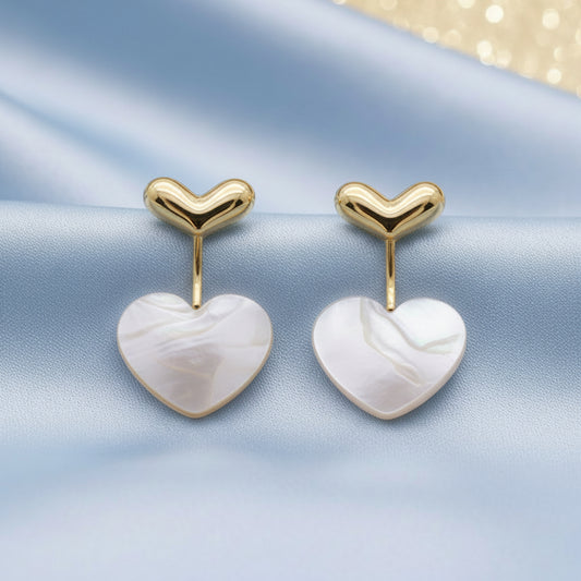 Mother of Pearl Double Heart Drop Earrings on a blue background
