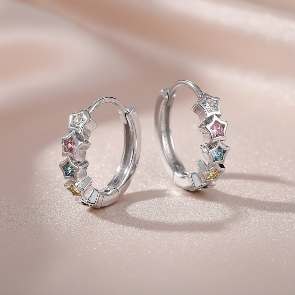 Multicolor Star Hoop Earrings with colorful gemstones on a light pink background