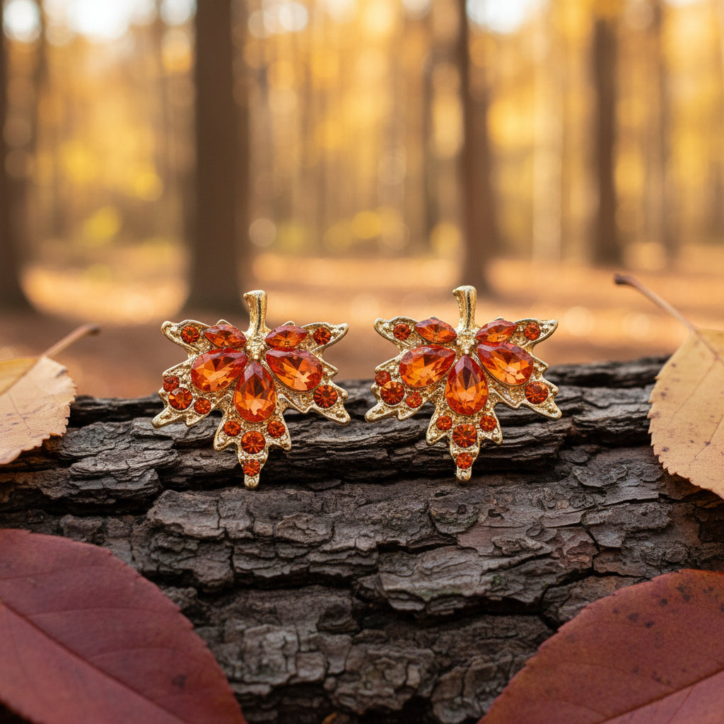 Orange Crystal Maple Leaf Earrings on wood