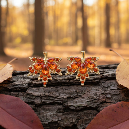 Orange Crystal Maple Leaf Earrings on wood