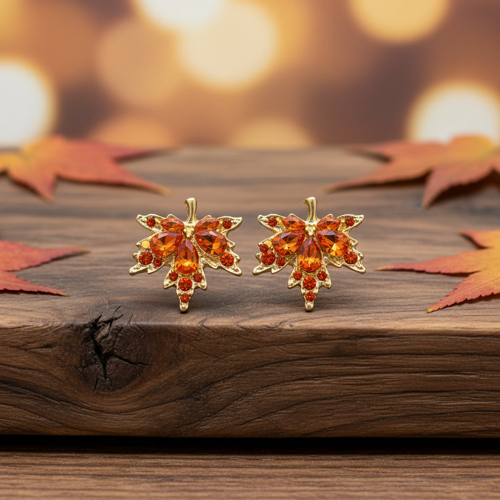 Orange Crystal Maple Leaf Earrings on wood table