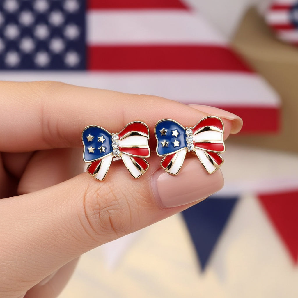 Patriotic Red White & Blue Bow Earrings with American flag design on a hand.
