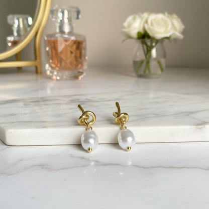 Pearl Knot Drop Earrings on marble