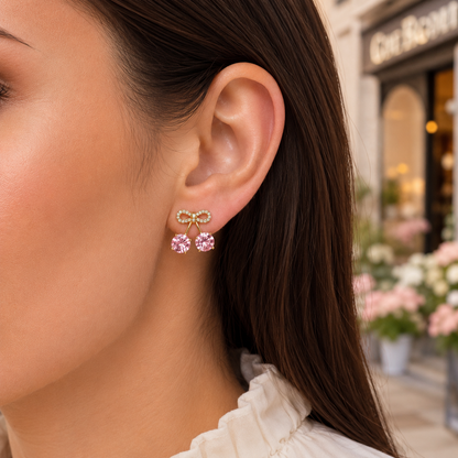 A close-up of a woman's ear wearing a pair of Pink Cherry Pavé Bow Earrings