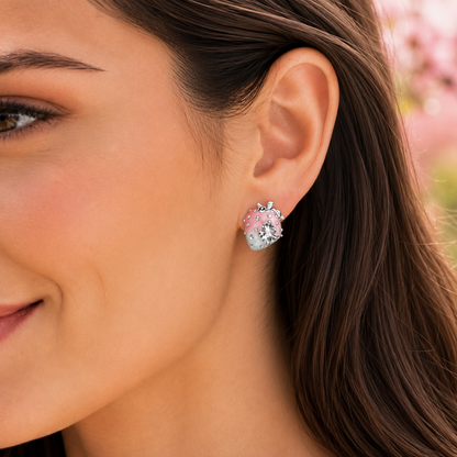 A close-up of a woman's ear wearing a Pink Ombré Crystal Strawberry Earrings with pink and white enamel details and a silver-toned top.