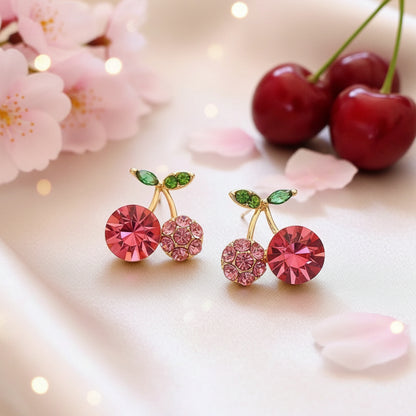 Pink Zircon Cherry earrings with red and green gemstones on a beige background