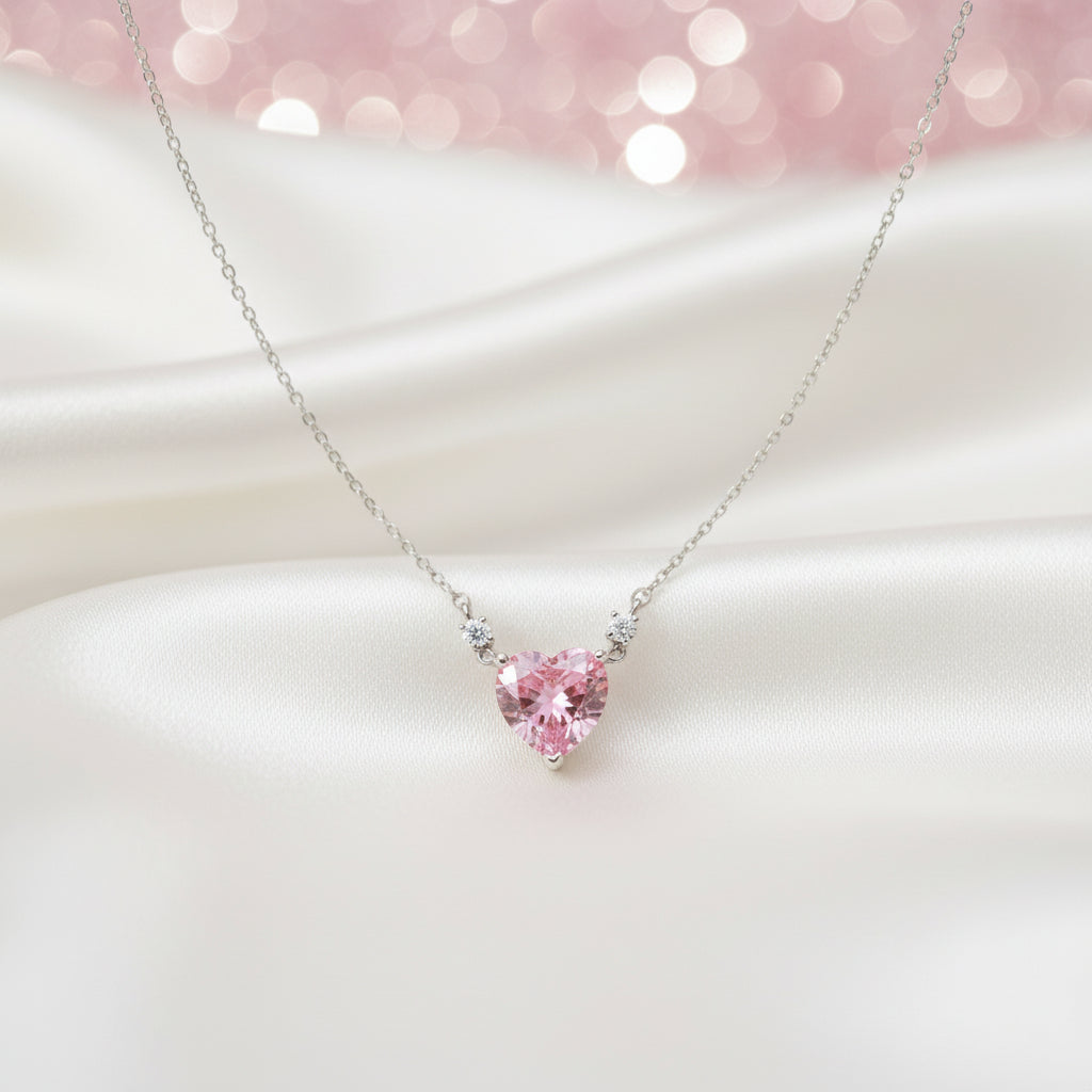 Pink Zirconia Heart Necklace on a white surface with a soft pink blurred background