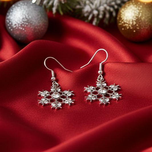 Silver snowflake earrings with clear gemstones on a white background