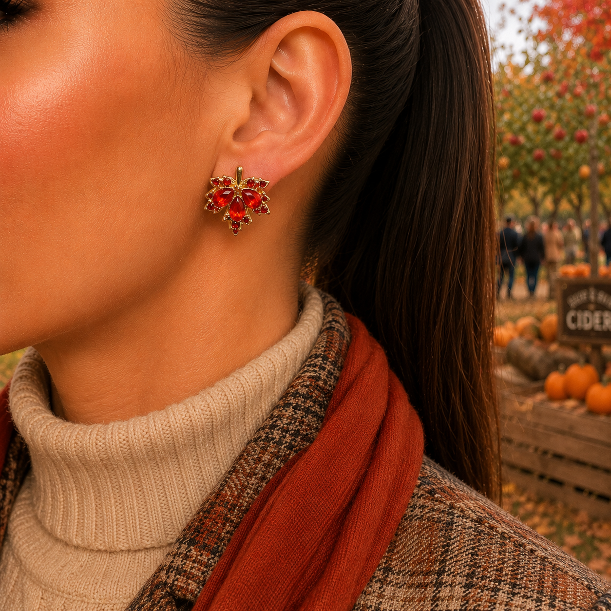 A close-up side profile of a woman wearing a Red Crystal Maple Leaf Earrings, styled with a beige turtleneck, rust-colored scarf, and plaid coat, set against an autumn outdoor background with pumpkins.