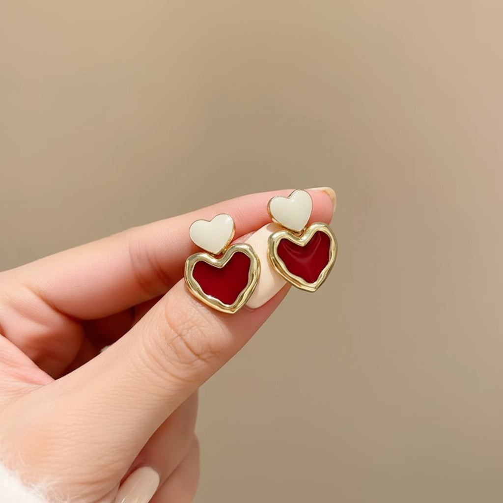 Hand holding the Red & White Double Heart Drop Earrings