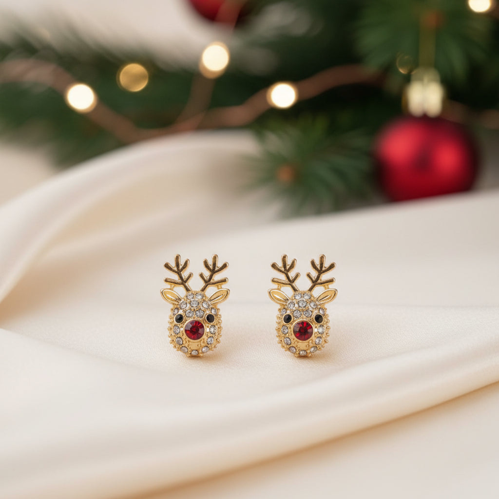 Rudolph Red Nose Reindeer Earrings on a wooden stand, surrounded by pink flowers.