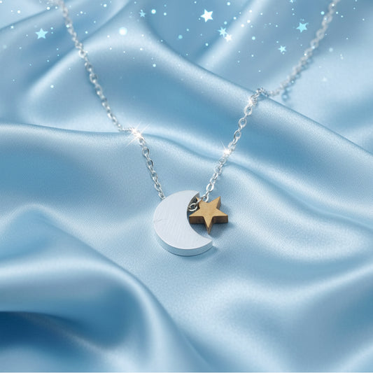 Silver & Gold Crescent Moon Star Necklace on a blue satin background