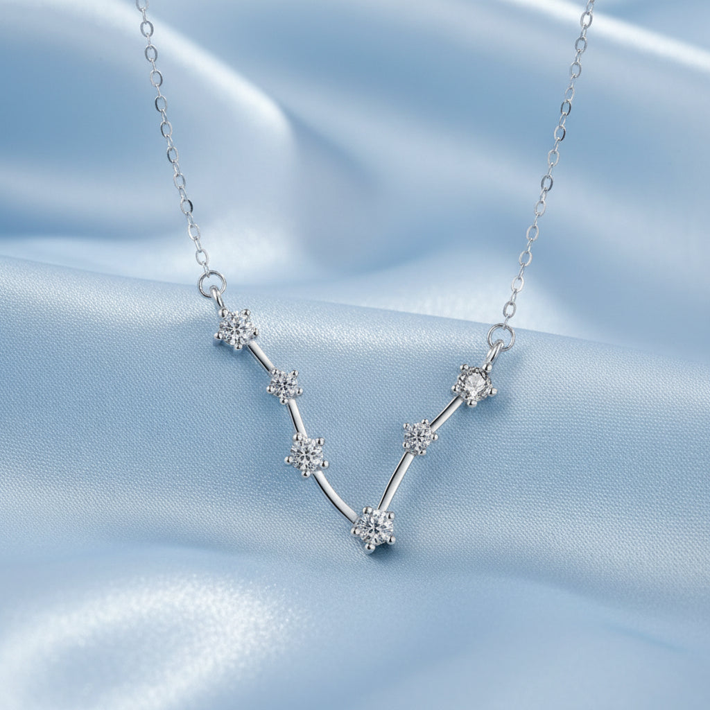 Silver Pisces zodiac necklace on a light gray background