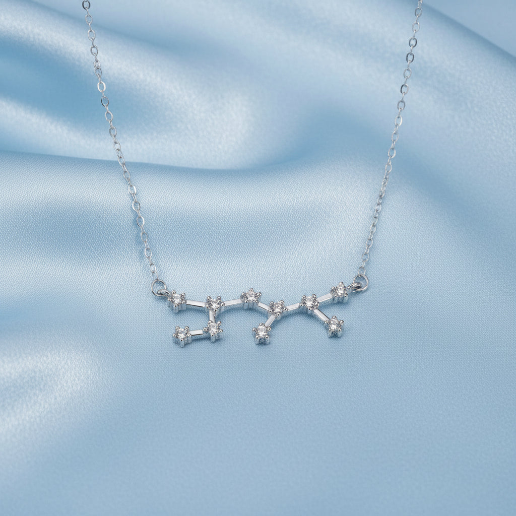Silver Sagittarius Zodiac Necklace with star-shaped pendant on a light blue fabric background