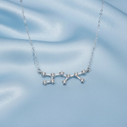 Silver Sagittarius Zodiac Necklace with star-shaped pendant on a light blue fabric background
