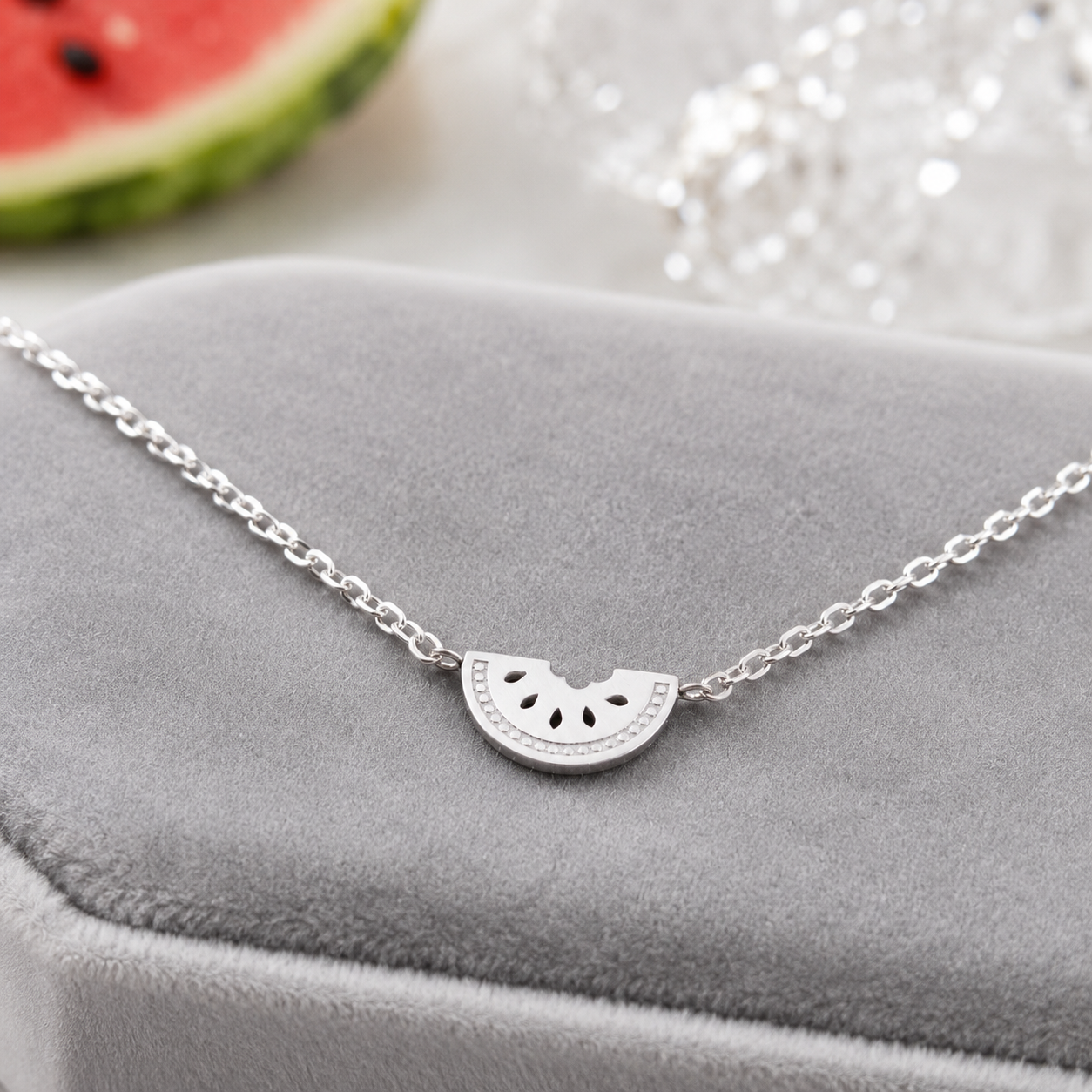 Silver Watermelon Slice Necklace on a gray surface