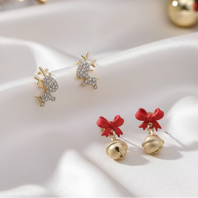 Gold Zircon Reindeer & Jingle Bell Bow Earring Bundle on a white fabric background