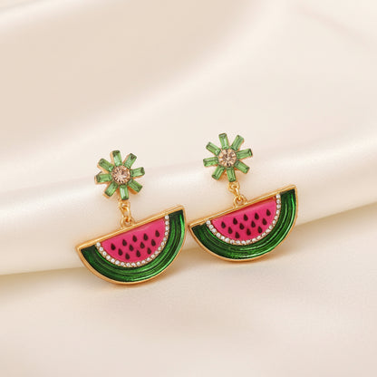 Watermelon Slice Dangle Earrings with green and pink design on a beige background