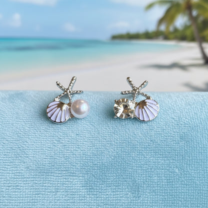 White Shell Pearl & Crystal Starfish Earrings on a light blue fabric on a beach