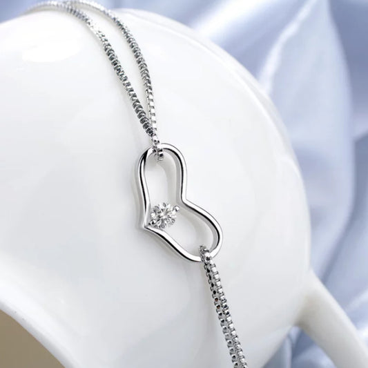 Silver Zirconia Heart Bracelet on a white stand against a light blue background