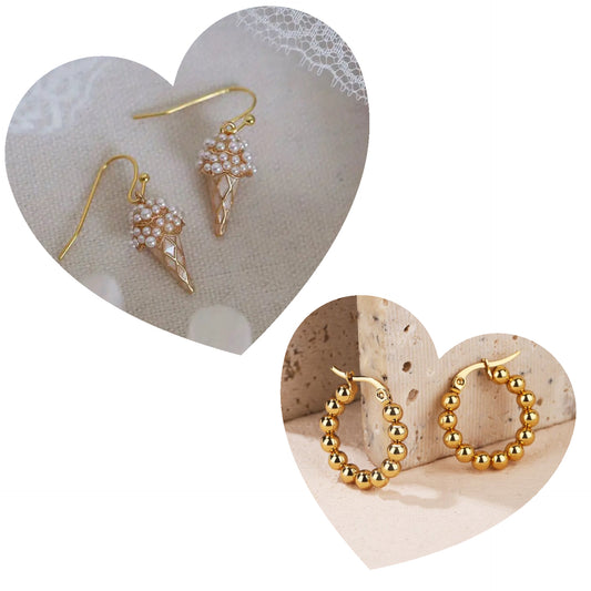 Gold ice cream cone-shaped earrings on a heart-shaped stone with gold hoop earrings on another heart-shaped stone.