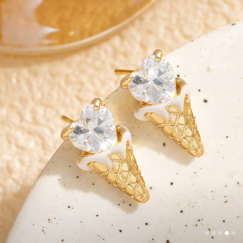 Crystal Heart Ice Cream Cone Earrings with clear gemstones on a textured beige surface.