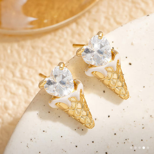 Crystal Heart Ice Cream Cone Earrings with clear gemstones on a textured beige surface.