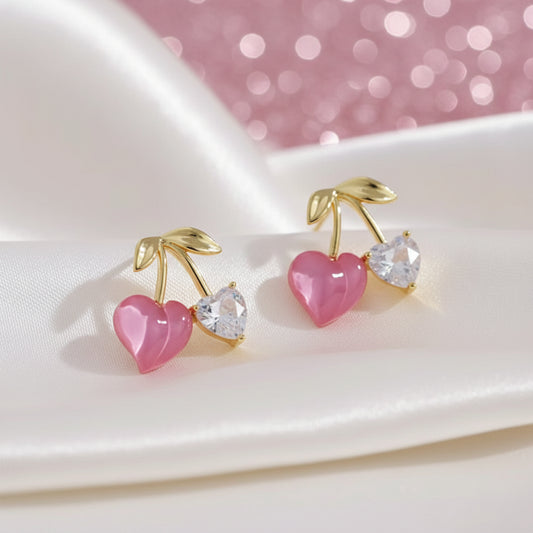Pink Cherry & Crystal Heart Earrings with pink hearts and gold accents on a white plate.