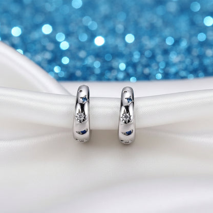 Celestial Star & Moon Hoop Earrings with embedded stones on a white surface