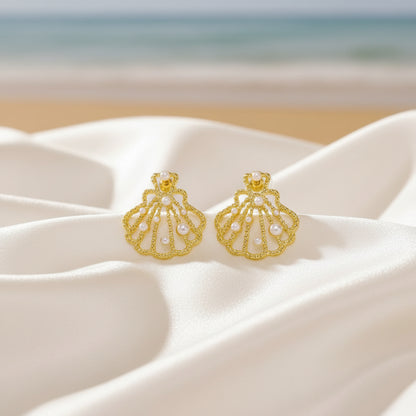Gold Seashell Pearl Earrings with a beach background