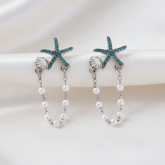 Blue Starfish Shell & Pearl Earrings on white fabric
