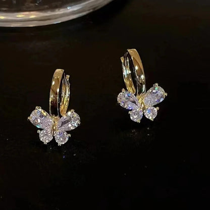 Gold Crystal Butterfly Hoop Earrings on a black table