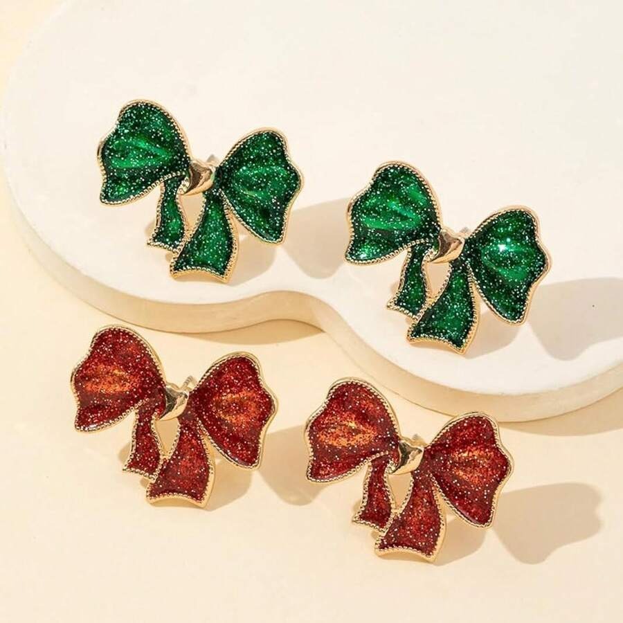 Pair of green and red bow-shaped earrings on a beige background
