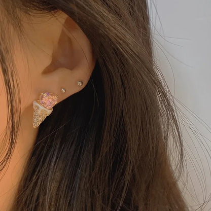Close-up of an ear with a Pink Heart Ice Cream Cone Earrings and other accessories.